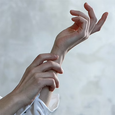 Photo of a person in a white long-sleeve shirt with both hands